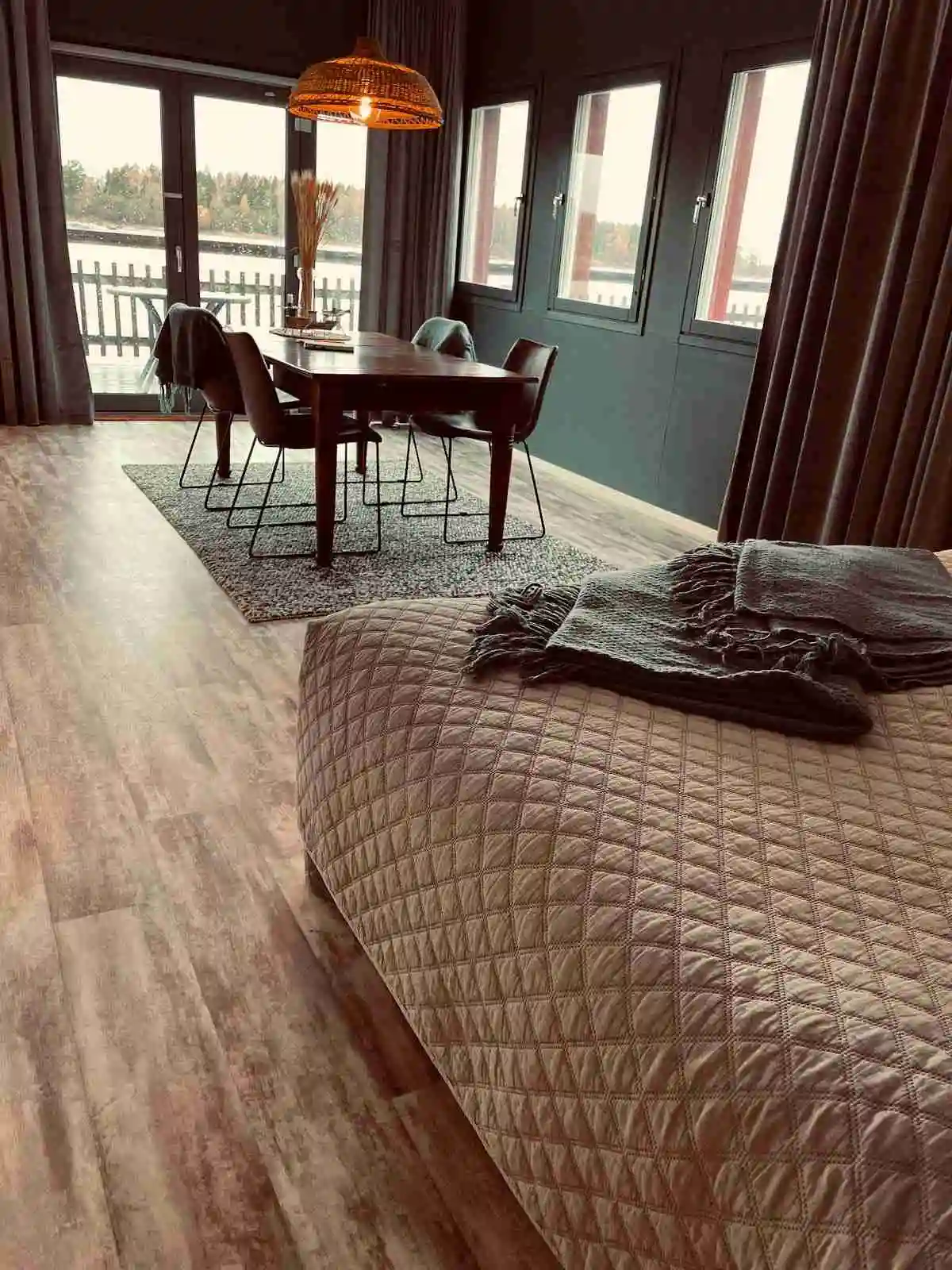 En interiörbild med ett inbjudande trälaminatgolv och bruna trädetaljer. Inomhusmiljön ger en varm och naturlig känsla.