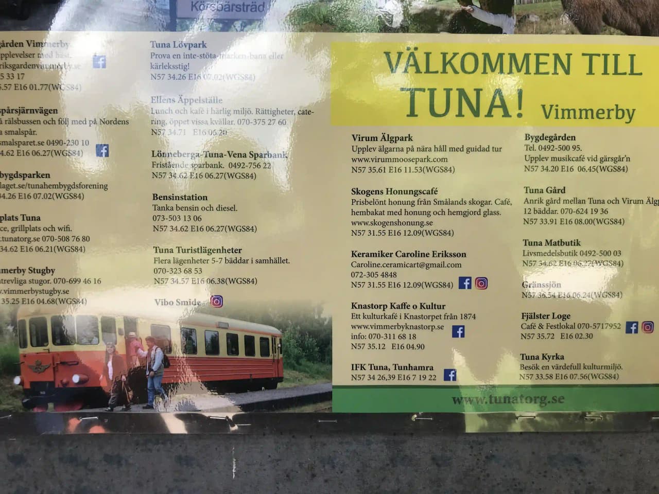 En passagerartåg på järnvägsspår i närheten av Vimmerby Camping - Nossenbaden, omgivet av grönskande natur.