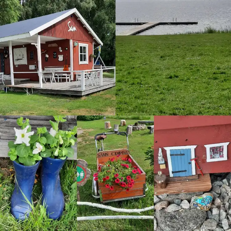 En idyllisk stuga omgiven av en välskött gräsmatta och trädgårdsmöbler. I bakgrunden skymtas en gårdsbyggnad och annan trädgårdsinredning, vilket skapar en hemtrevlig miljö vid Säms camping och café.