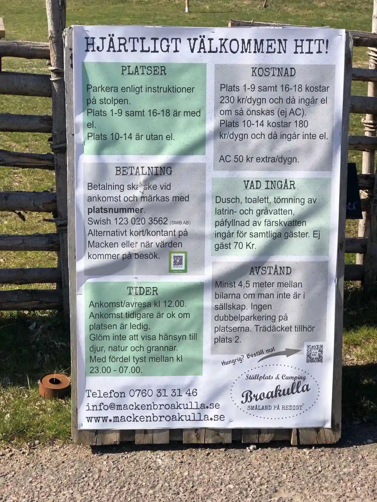 En skylt vid en grusväg omgiven av gräs, som visar vägen till Broakulla Ställplats & Camping.