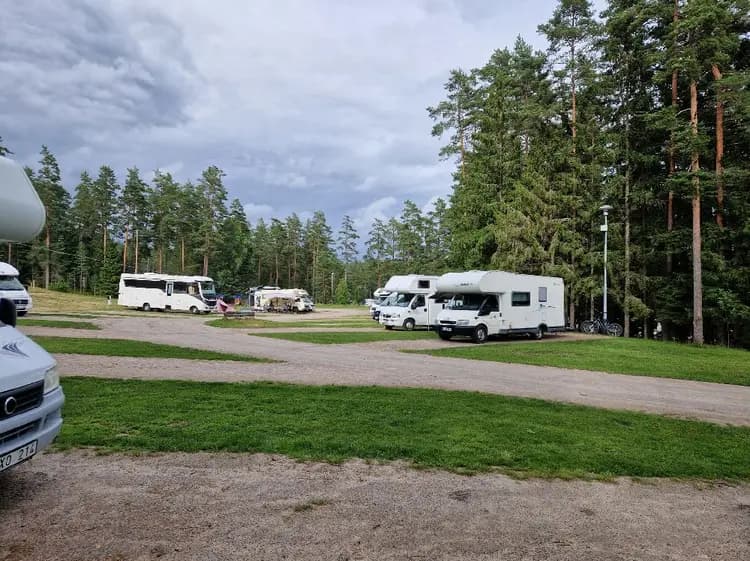 En campingplats vid Isaberg Mountain Resort med flera parkerade husbilar och campingvagnar. Fordonens parkeringsljus och sidospeglar syns tydligt. I bakgrunden skymtar träd och en del av resortens faciliteter.