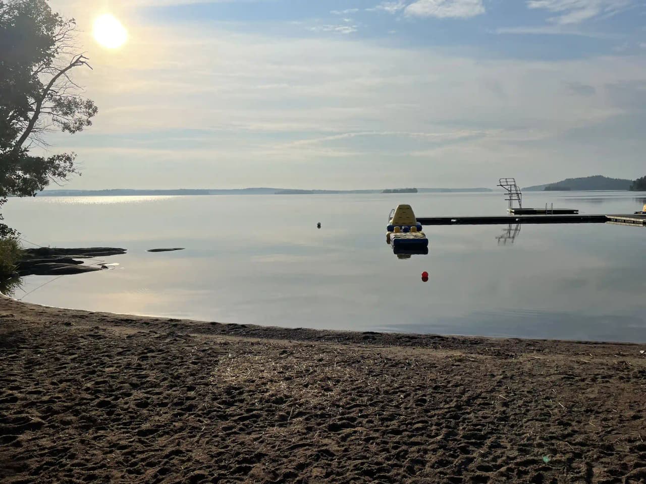 En vidsträckt vy över ett kustlandskap vid Björknäs camping, med horisonten i fjärran och lugnt vatten som sträcker sig mot kusten.