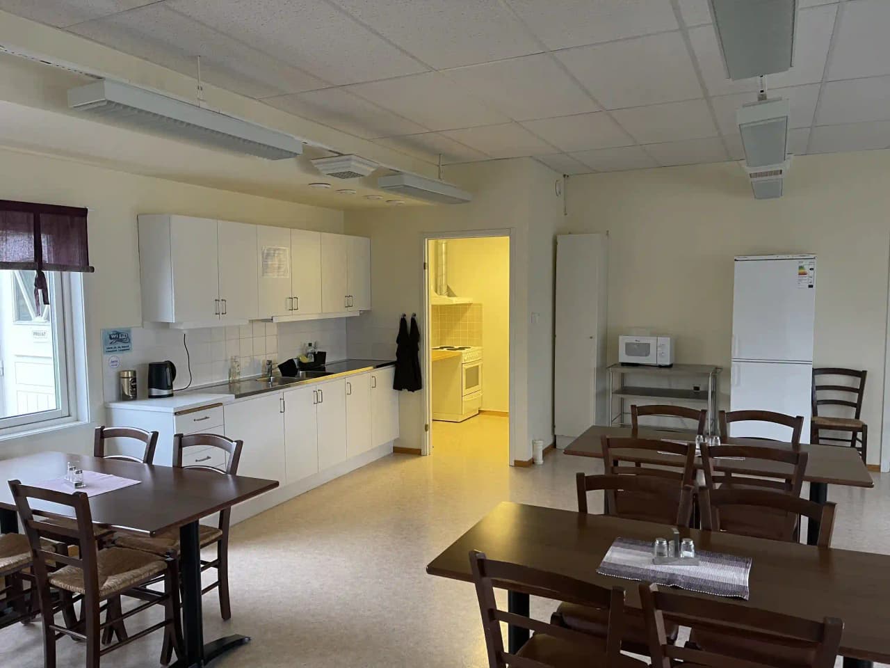 Ett interiörfoto från Åmsele camping som visar ett rum med trämöbler och trädetaljer. Det finns ett bord och stolar på ett trägolv, taket och väggarna har träelement och rummet är väl upplyst.