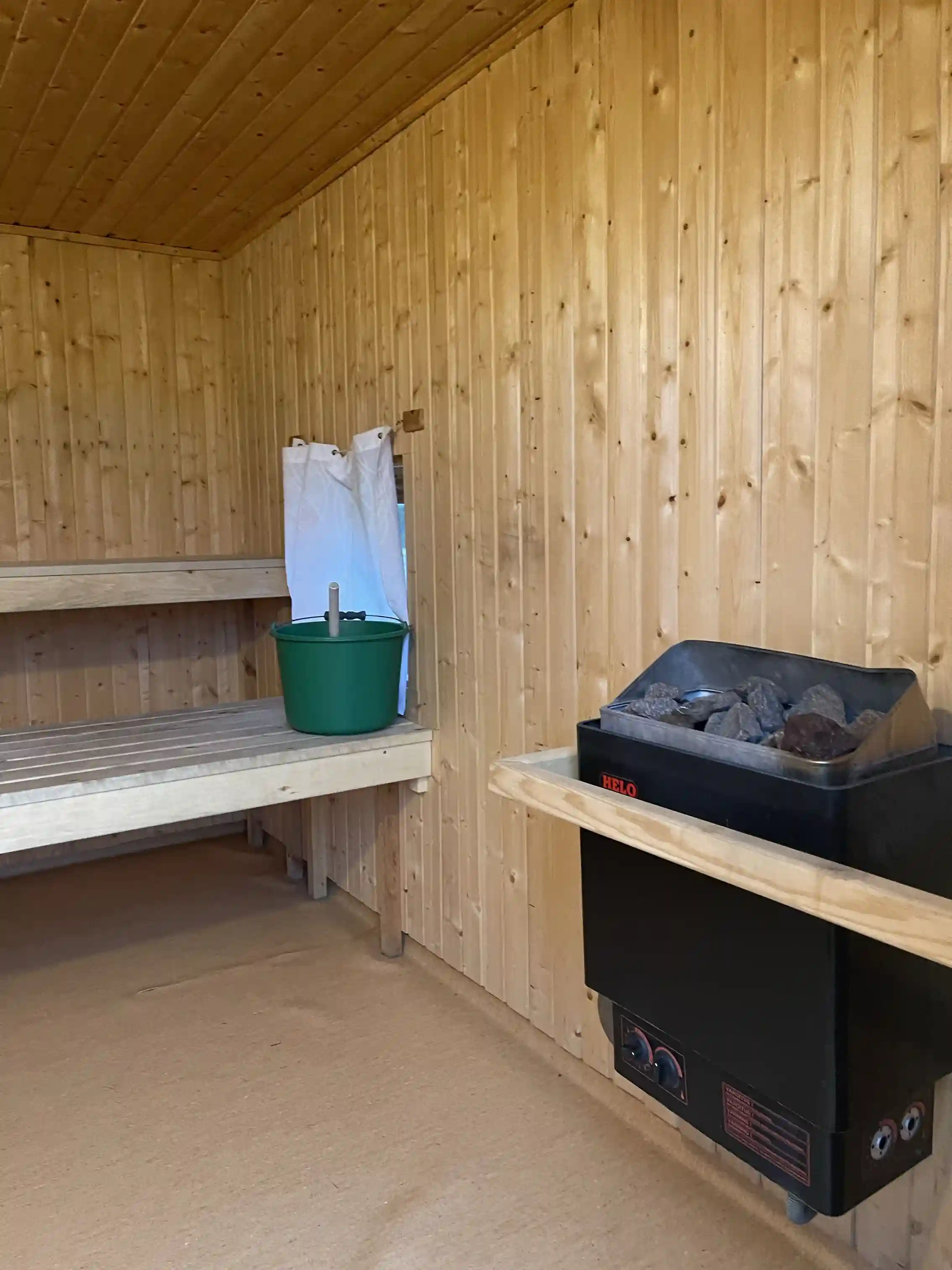 En träbyggnad vid Åmsele camping, byggd av robust trä med tydliga plankor och trädetaljer som framhäver byggnadens naturliga estetik.