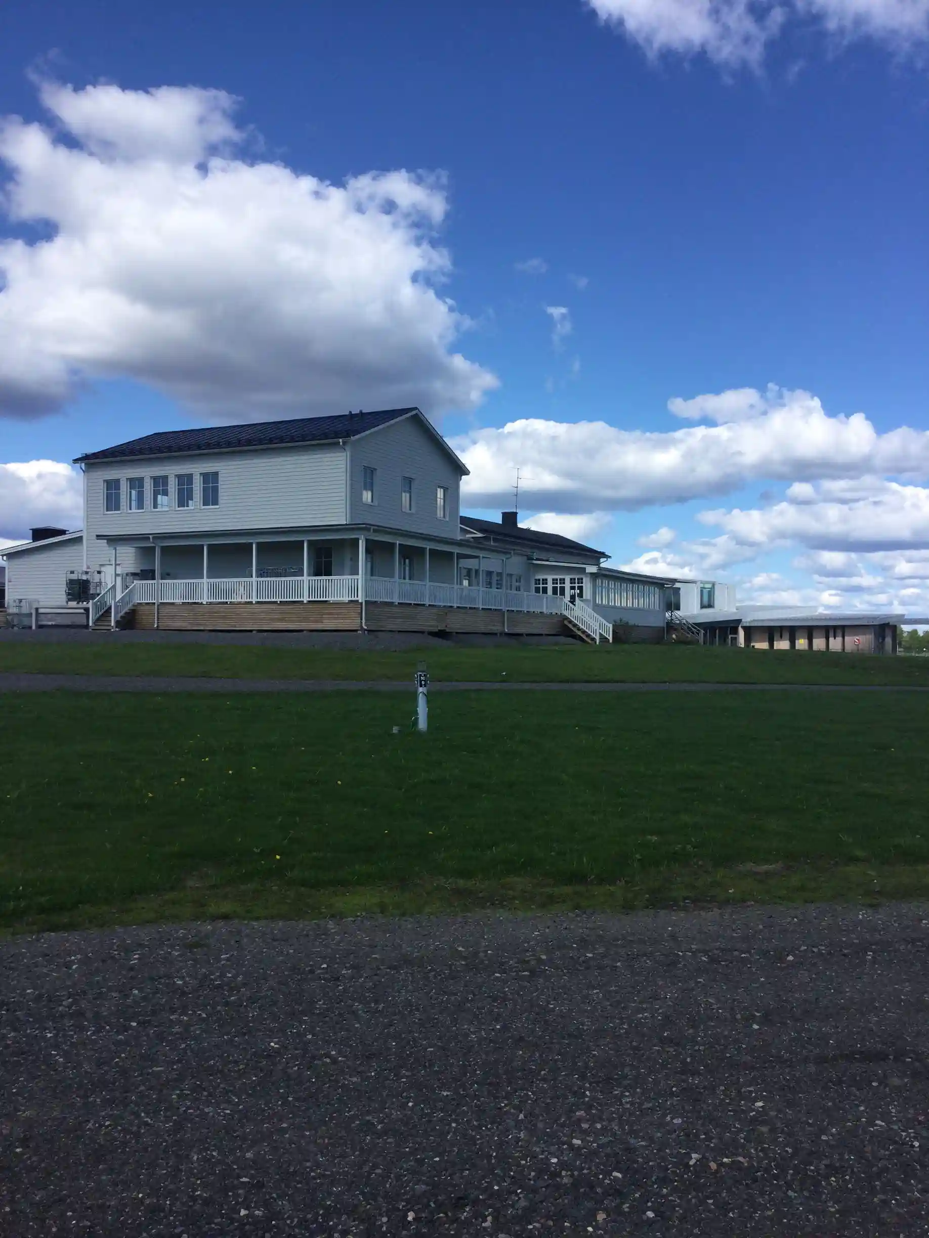 En stor stuga med gräsmatta under en molnig himmel vid Cape East, omgiven av öppet landskap.