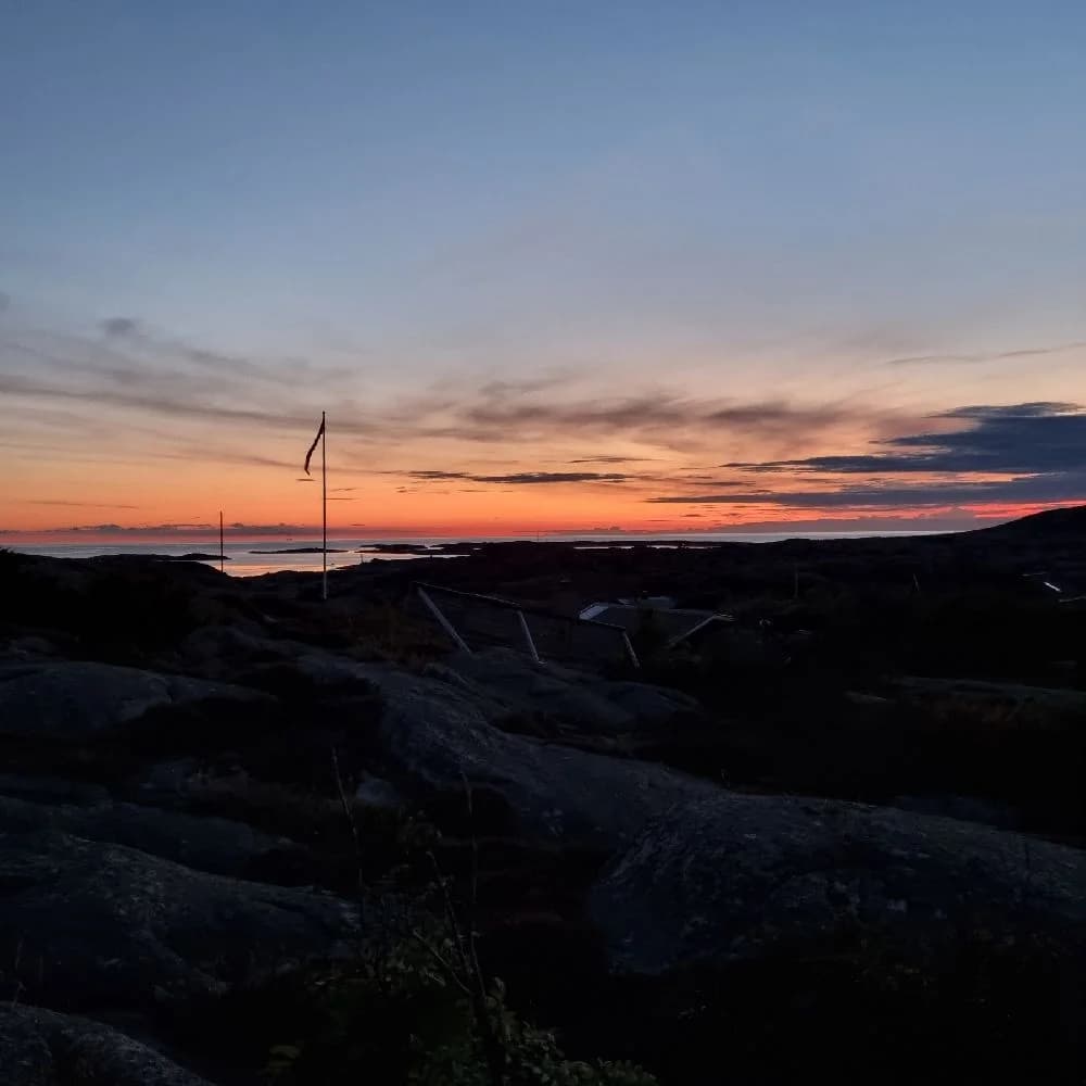 En vy av himlen vid skymning över Sotenäs Camping med en horisont präglad av varma orange och röda toner i solnedgången.