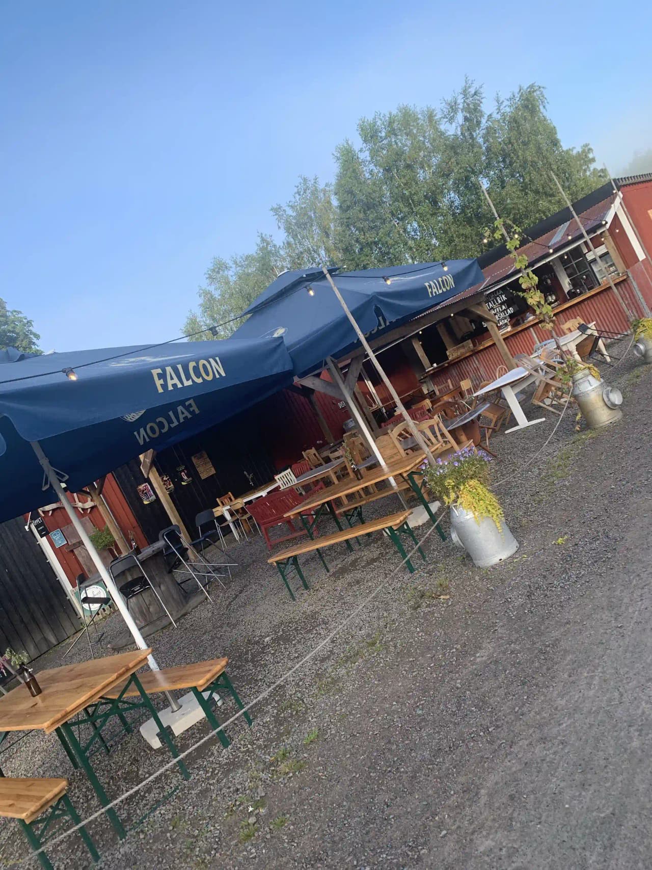 En restaurang med markiser och parasoller utomhus på Gunnagård.