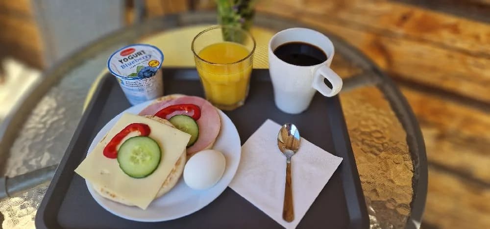 Ett dukat frukostbord i Hamra stugby med bröd, tallrikar, och dryck.