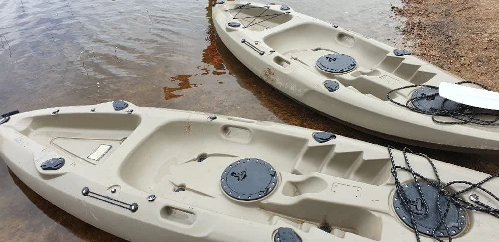 En bild av fritidsbåtar och båttillbehör vid Hamra Stugby, placerade nära vattnet under en klar himmel.