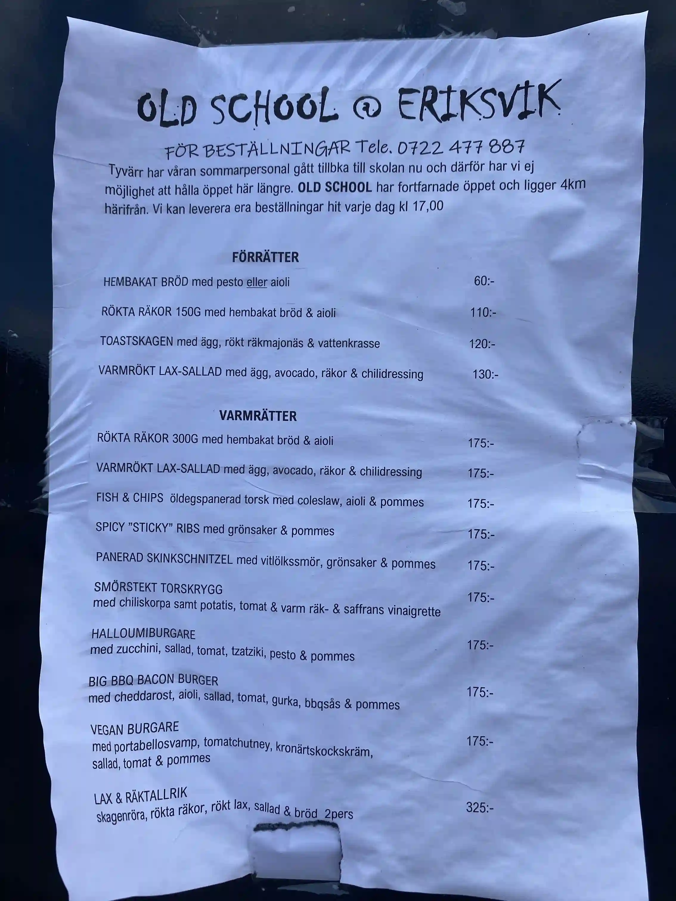 En närbild av Eriksviks hamn, som inkluderar handskriven text eller skyltar, vilket ger en rustik och personlig känsla av platsen.