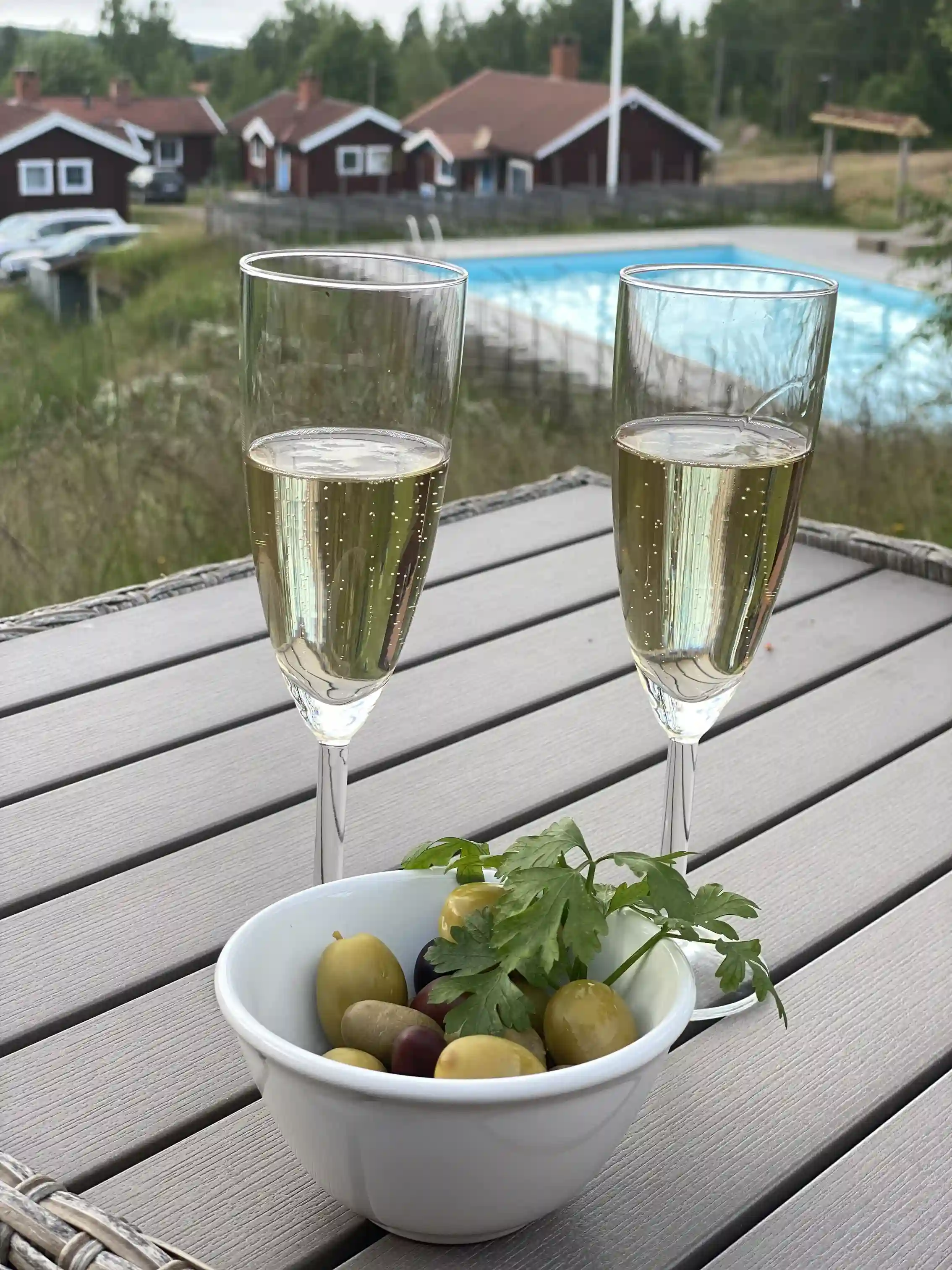 Alt-text: Ett elegant dukat bord med glas av olika slag på Åsengården, inklusive vinglas och champagneglas, vilket skapar en inbjudande atmosfär för besökare.