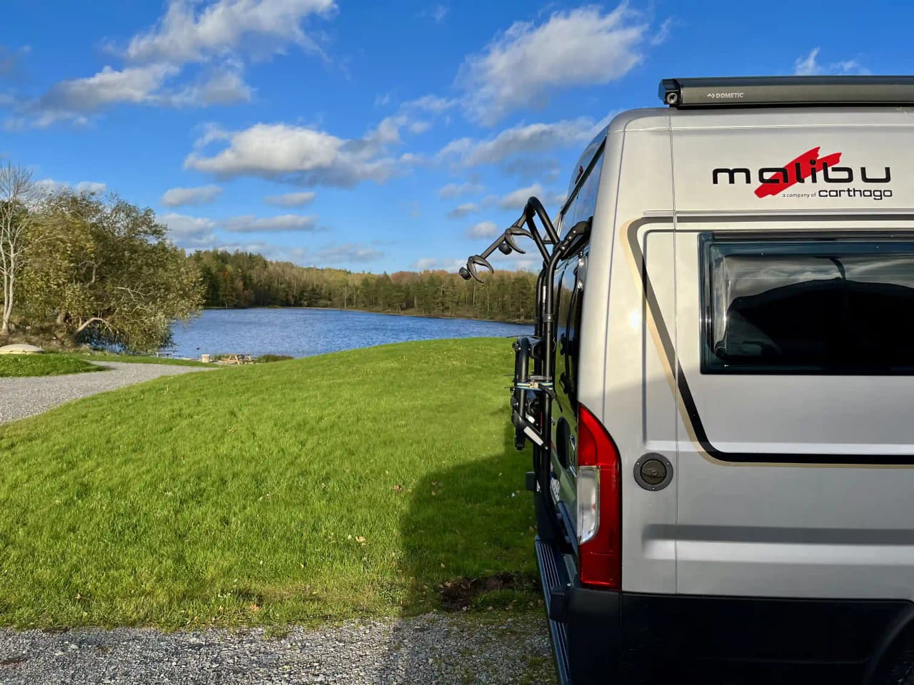 En bild av en gästhamn vid Upperuds där flera fordon, inklusive skåpbilar och fritidsfordon, står parkerade intill bryggor med räcken.