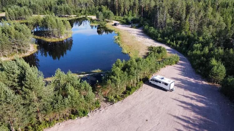 En rofylld sjö omgiven av tät skog i en vildmarksidyll nära Mora, perfekt för fiske och naturupplevelser.