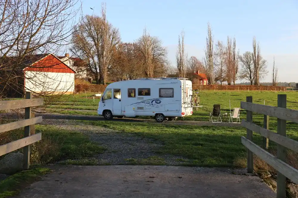 En husbil parkerad på Kedumsvik ställplats, omgiven av grönska.