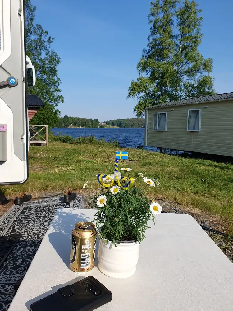 En husvagn och en husbil står parkerade på en gräsmatta på Snibbens camping.