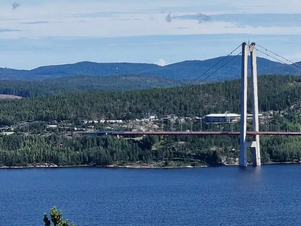 En kabelbro över en kustnära kanal omgiven av natursköna landskap nära Snibbens camping.