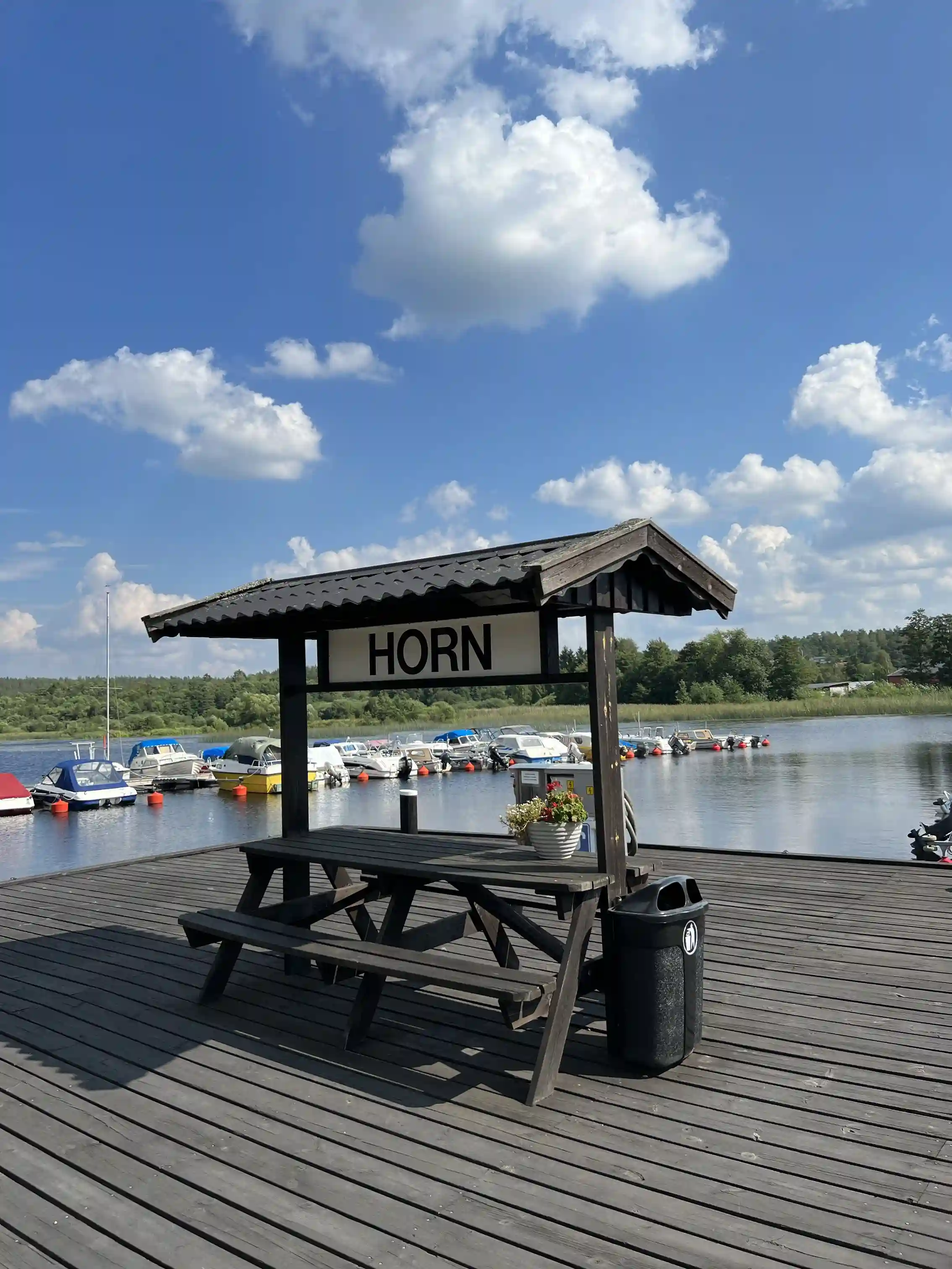 En rofylld brygga vid Södra Kinda Båtklubb, med båtar förtöjda vid bryggan och en vacker utsikt över sjön, perfekt för fritidsaktiviteter och avkoppling.