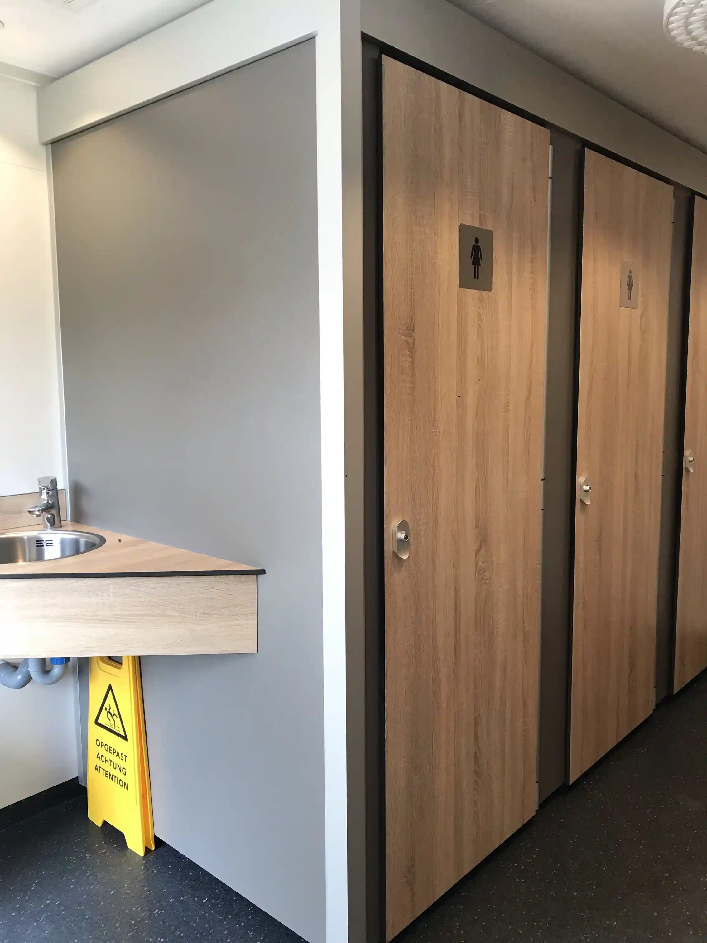 Ett interiörfoto från Våmåbadets camping som visar ett rum med trägolv och träpaneler på väggar och tak. Färgsättningen är en kombination av olika trätoner och i rummet finns även en inslag av en taklampa och plastdetaljer.