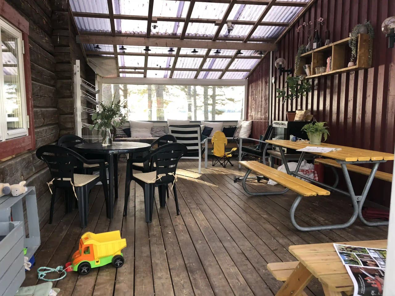 En bild av interiören på Våmåbadets camping med träinredning. Rummet innehåller möbler såsom bord och stolar, samt en blomkruka som dekoration. Golvet är av trä och passar in i den rustika inredningen.