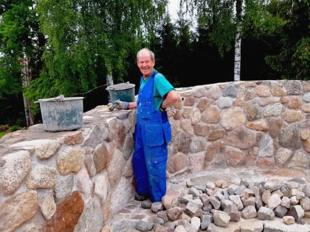 En stenvägg av ojämna stenblock, typiska för historiska byggnader, är i fokus. Den robusta strukturen skapar en rustik och charmig atmosfär vid Moarps B&B.