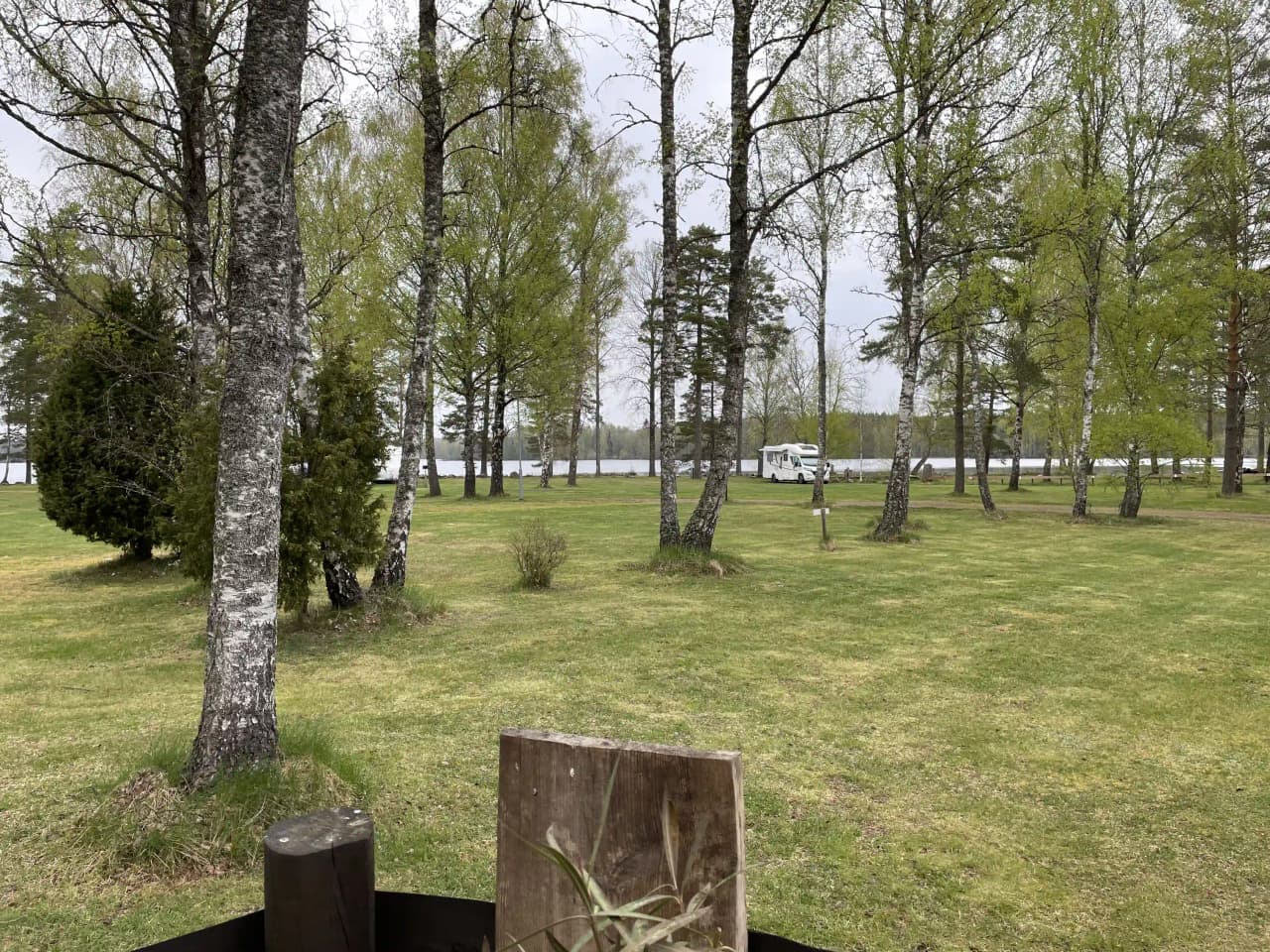 En lugn campingplats i Orrefors med gröna gräsytor, omgivna av träd och parklandskap.