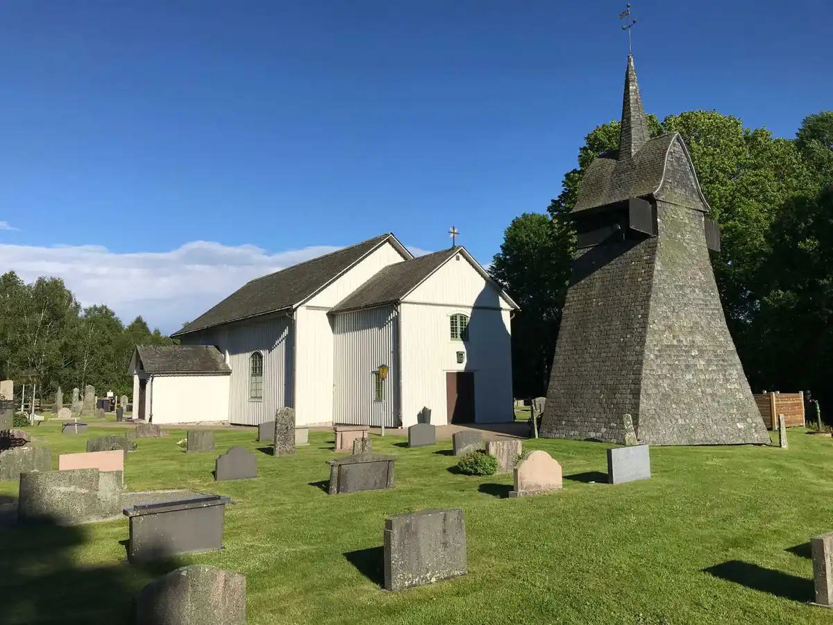En välskött gravplats med en gravsten, omgiven av grönt gräs och vacker landskapsarkitektur på Kerstins camping.