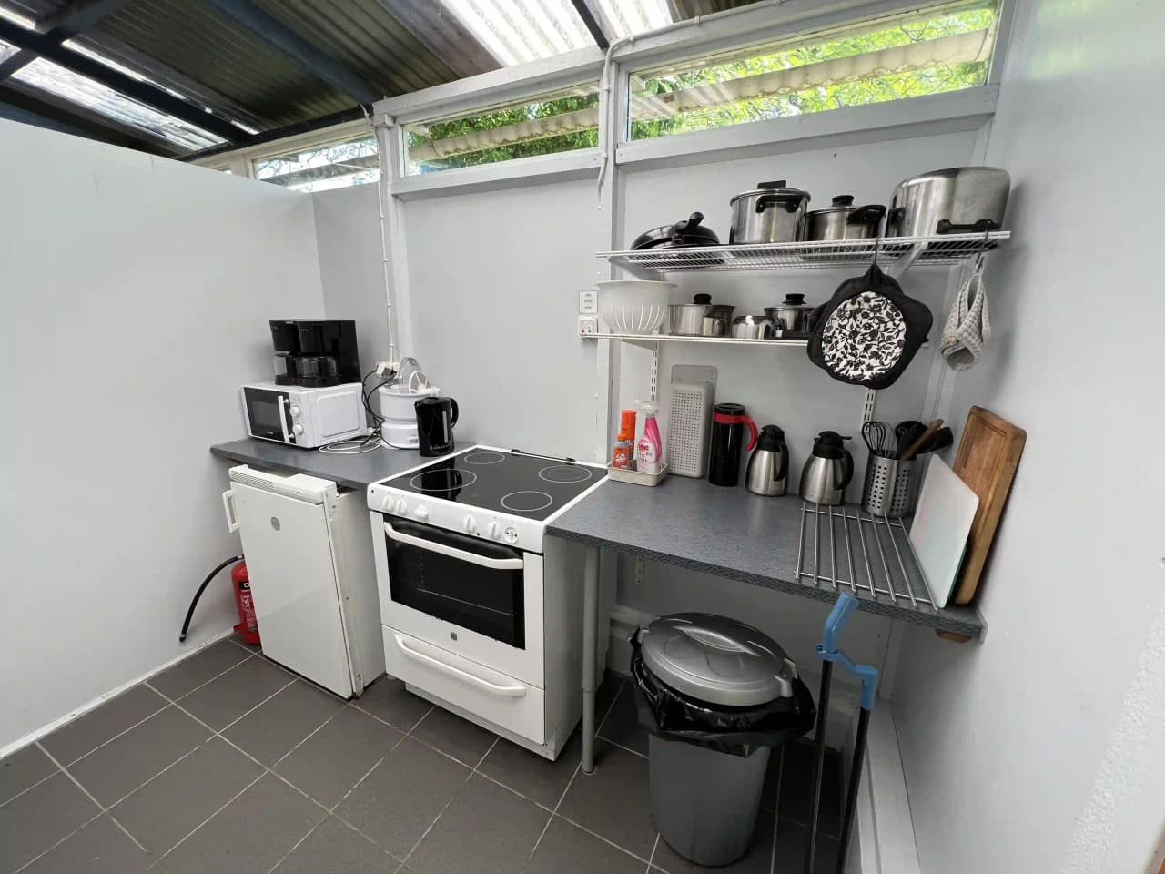 Bild av ett kök på Björkenäs Camping med moderna vitvaror, bänkskiva och skåpinredning.