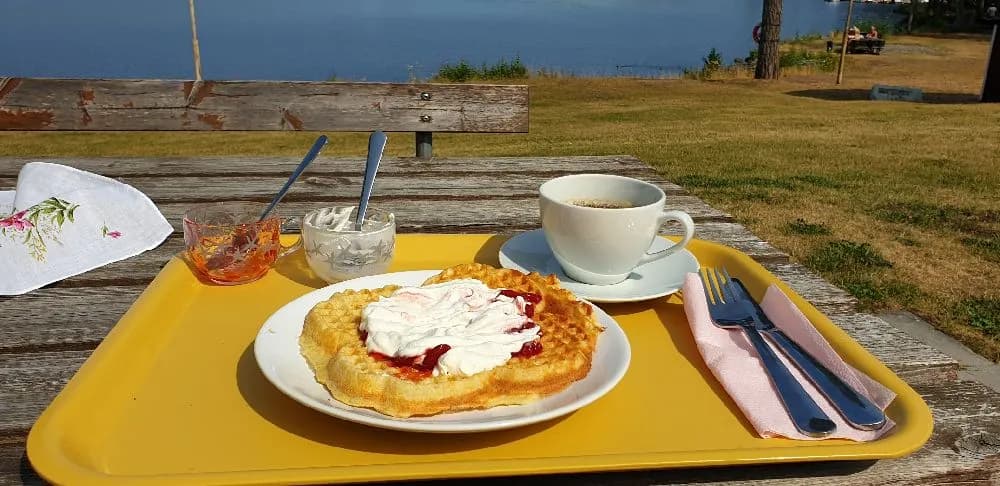 En frukost dukad på ett bord med olika matvaror och drycker. Tallrikar, glas och bestick är placerade runtom.