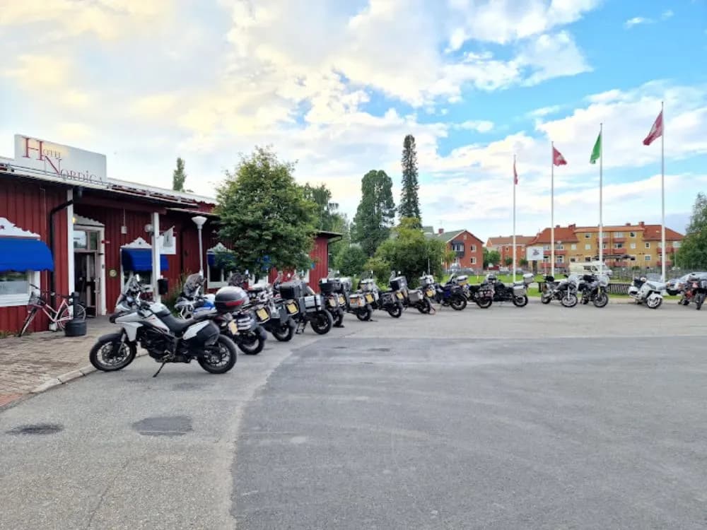 En motorcykel parkerad framför Hotel Nordica med tydliga detaljer av hjul och belysning.