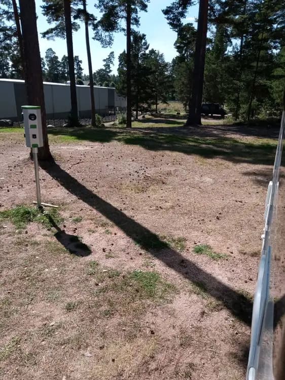 En grönskande park med en välskött gräsmatta, en bred uppfart och en naturlig stig som slingrar sig genom landskapet vid Nyhemsgården.