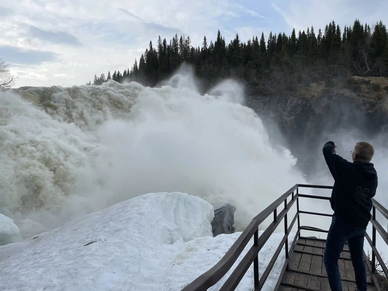 En mäktig vattenfall som forsar ner i en ström omgiven av frodig grönska vid Tännforsens turiststation.