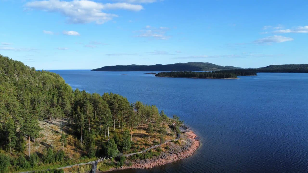 Utsikt över Måvikens camping & naturområde med vattenresurser och varierad natur, där en sjö möter kustnära landformer och högländer.