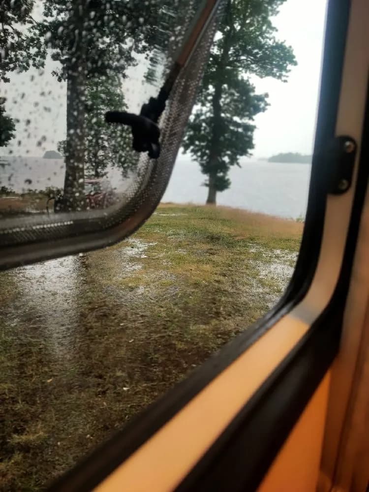 En morgonbild där solsken speglas i en bils sidospegel vid Hägern Bed & Nature. Glaset på spegeln reflekterar omgivningen som inkluderar element av kollektivtrafik.