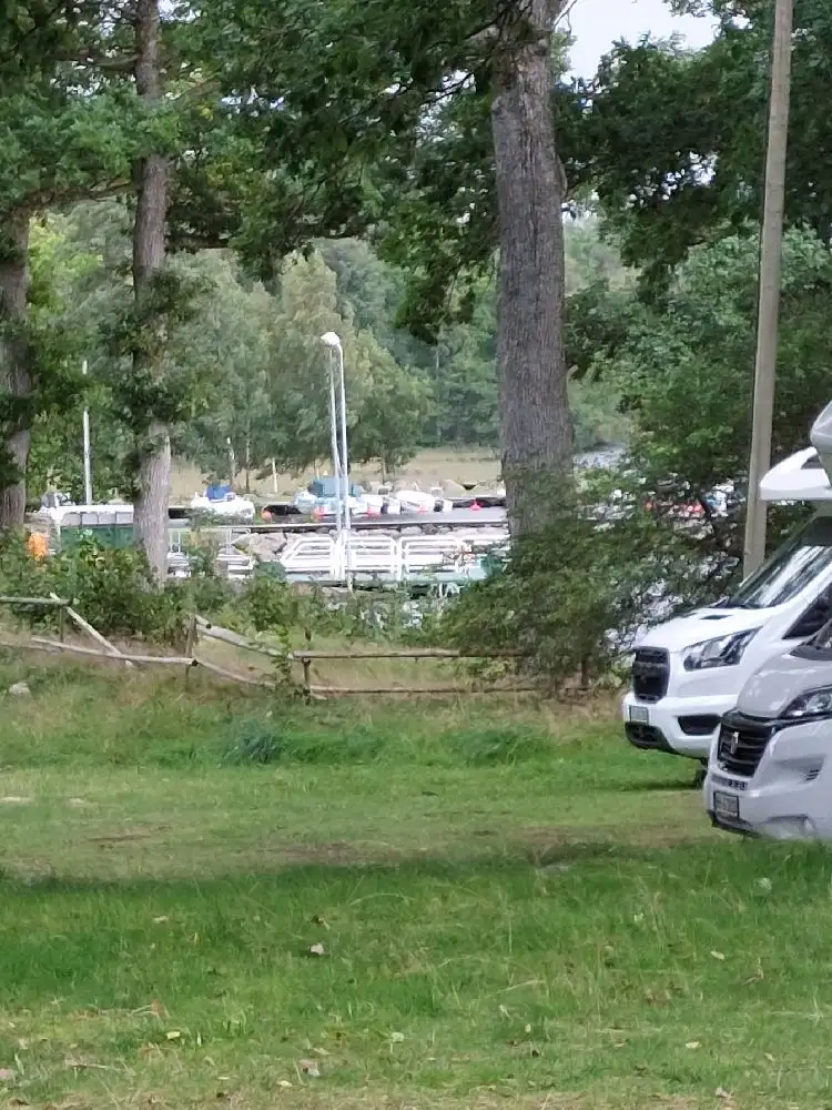 En lyxbil parkerad utomhus framför Hägern Bed & Nature. Registreringsplåten och bilens bakljus syns tydligt.