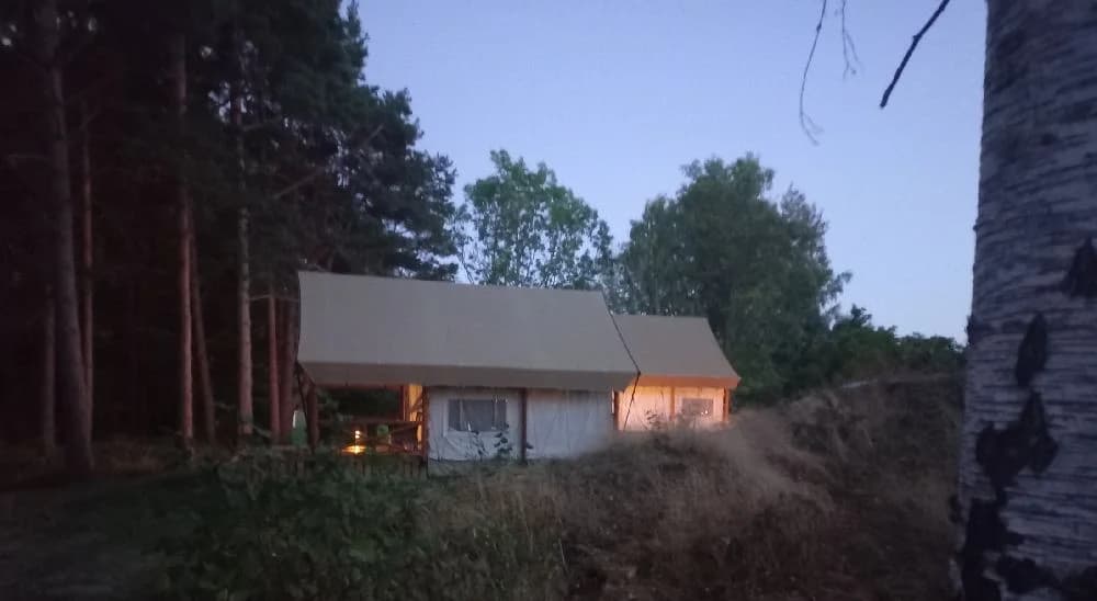 En stuga omgiven av grönskande trädgård vid Gålö havsbad, med en rustik känsla av friluftsliv och avkoppling nära naturen.