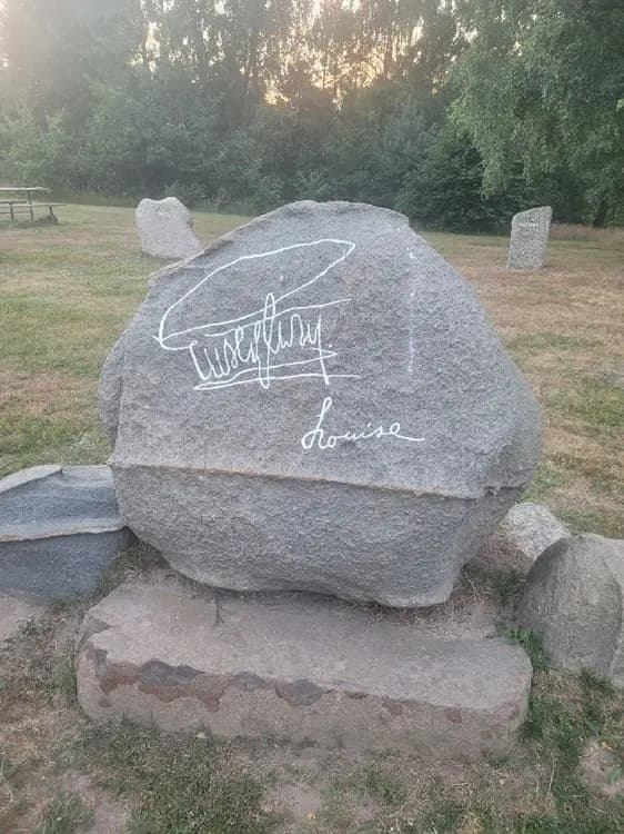 En bild av Orebackens Camping som visar en stor klippformation och några stenar i en naturskön parkmiljö.