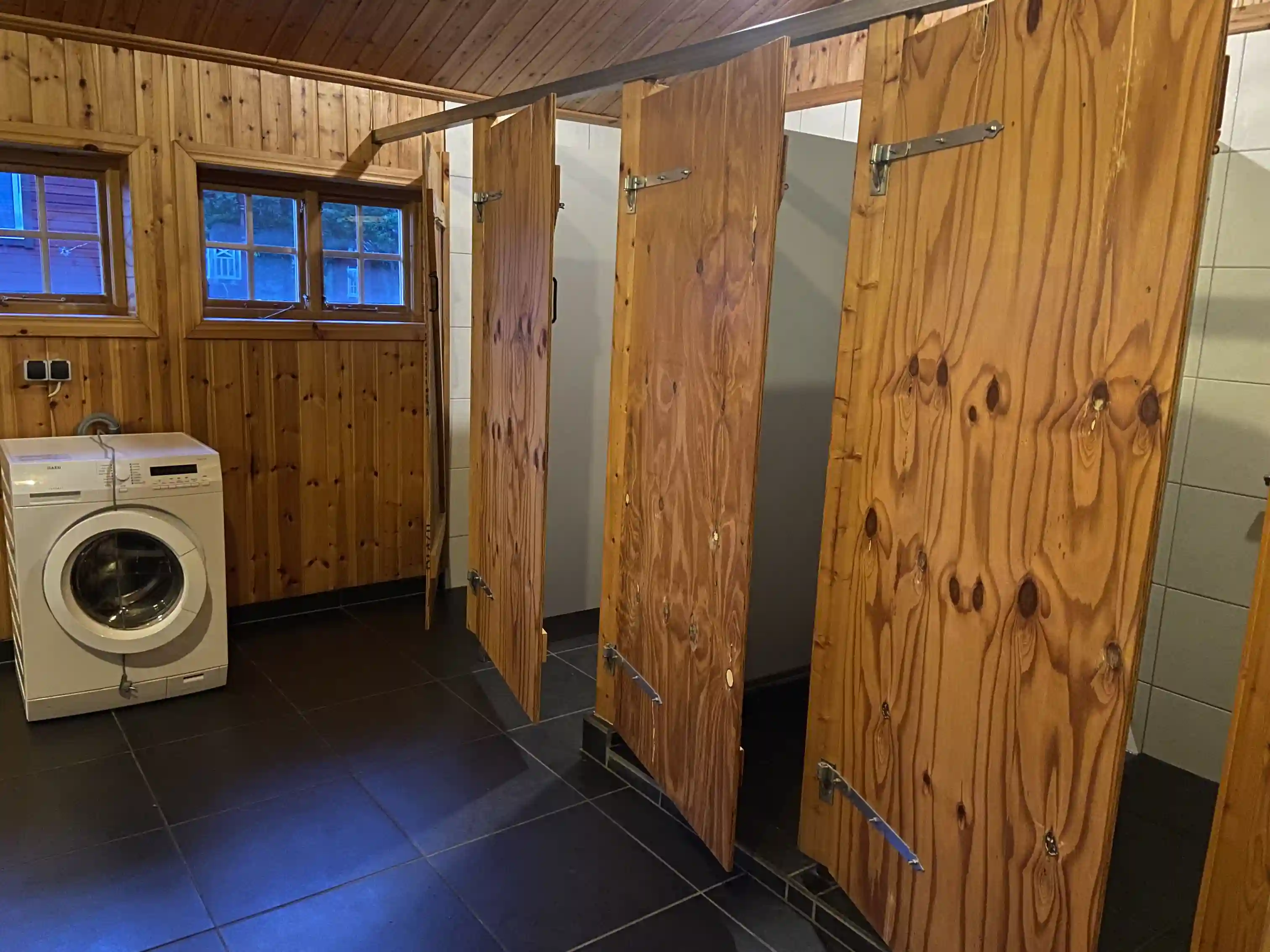 En interiör av ett träbeklätt rum med ljusa trägolv och mörkare träpaneler på väggarna, vilket ger en rustik känsla.