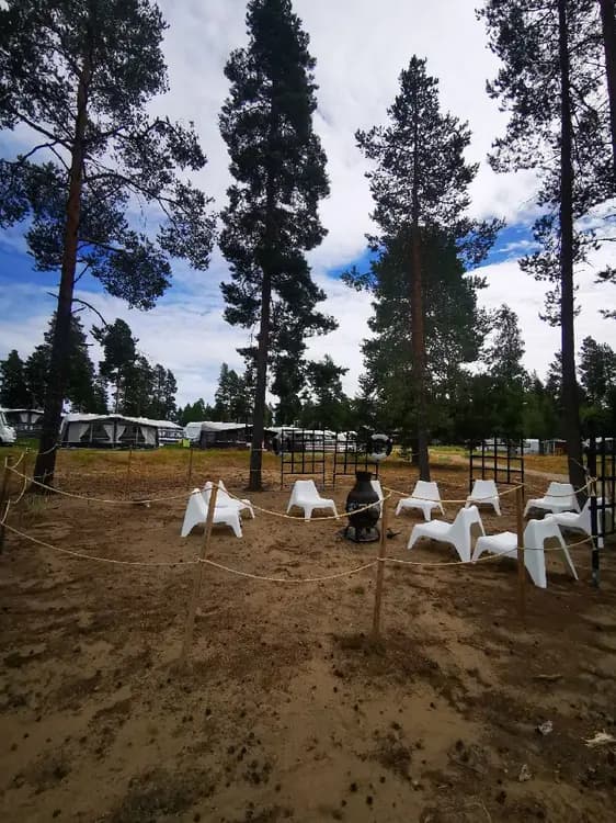 En campingplats på Bovikens havsbad med tält och solskydd uppsatta i en lummig parkmiljö.