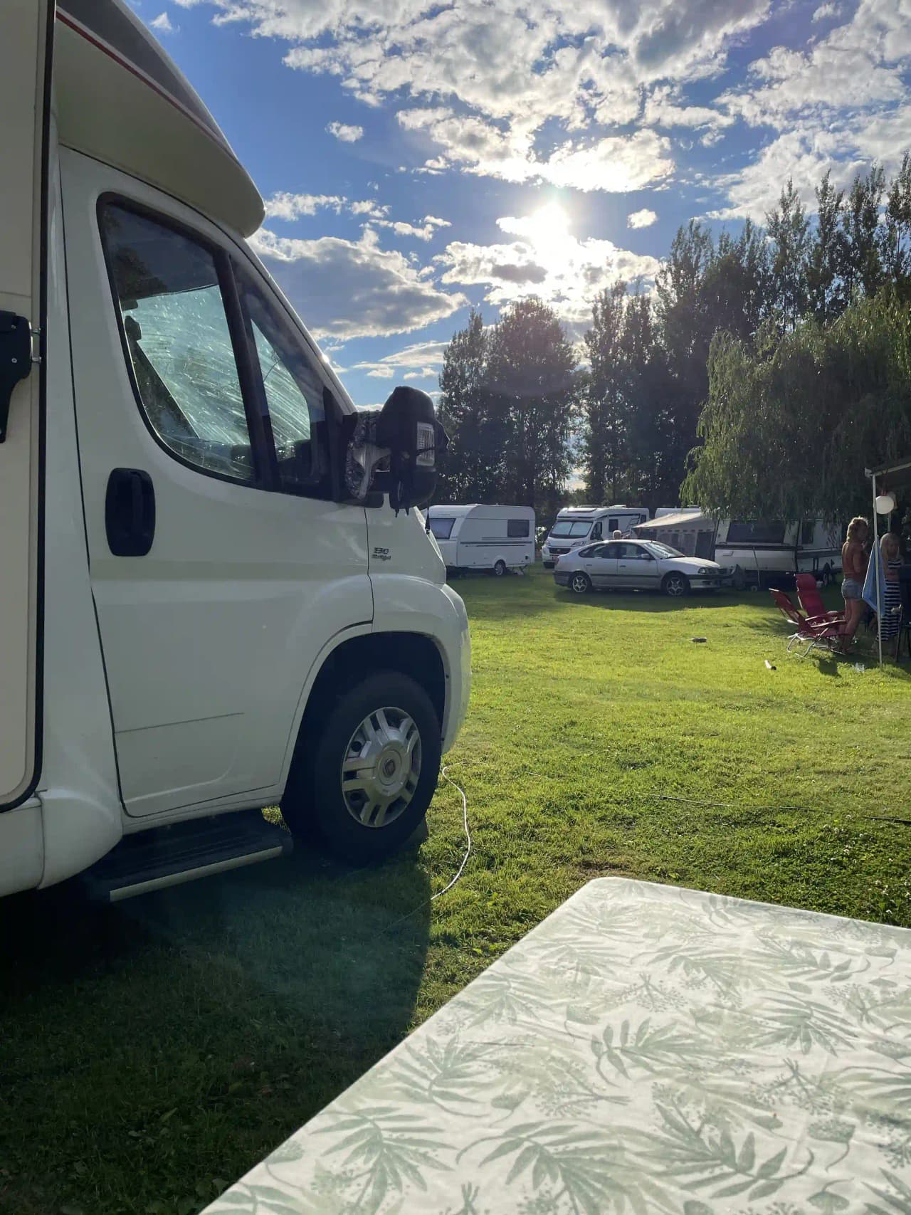 En husbil och husvagn parkerade på en gräsmatta vid Säters Camping.