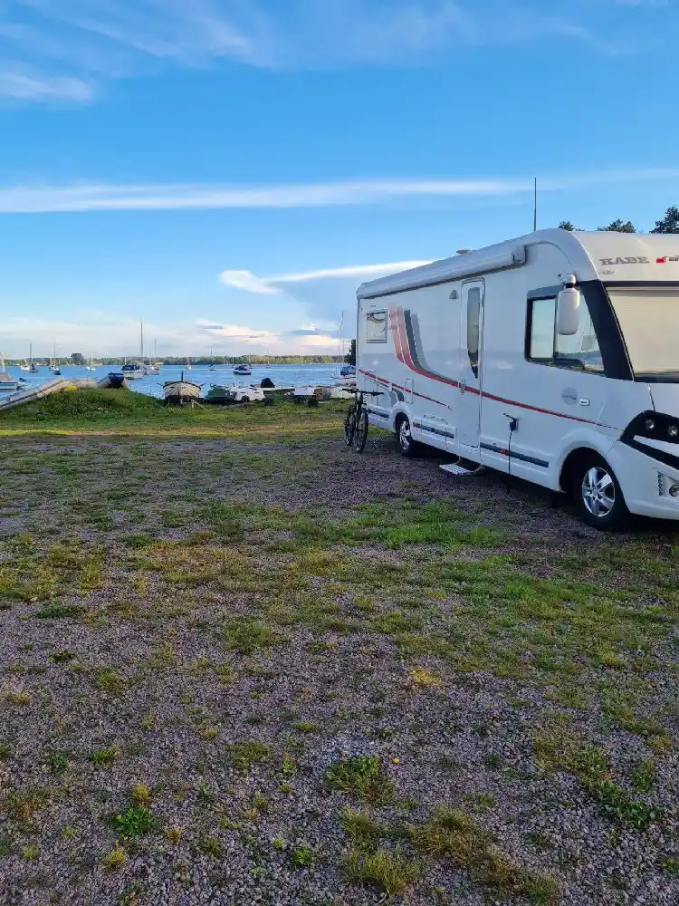 En husvagn med tillhörande cykel är parkerad på Gripenbergs gård. I bakgrunden syns fler husvagnar och ett grönområde.