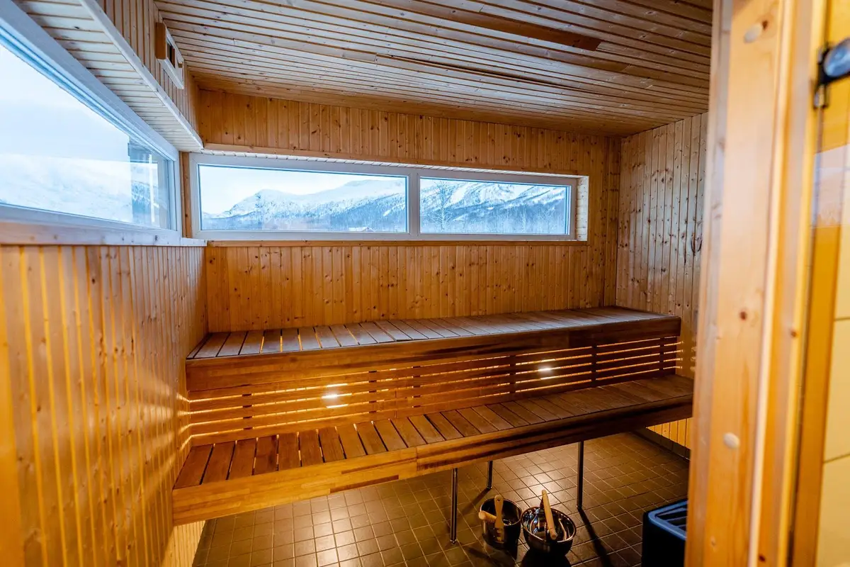 Interiör av en stuga på Camp Kittelfjäll med träpanel i taket, träfärgad inredning och naturligt dagsljus som strömmar in.