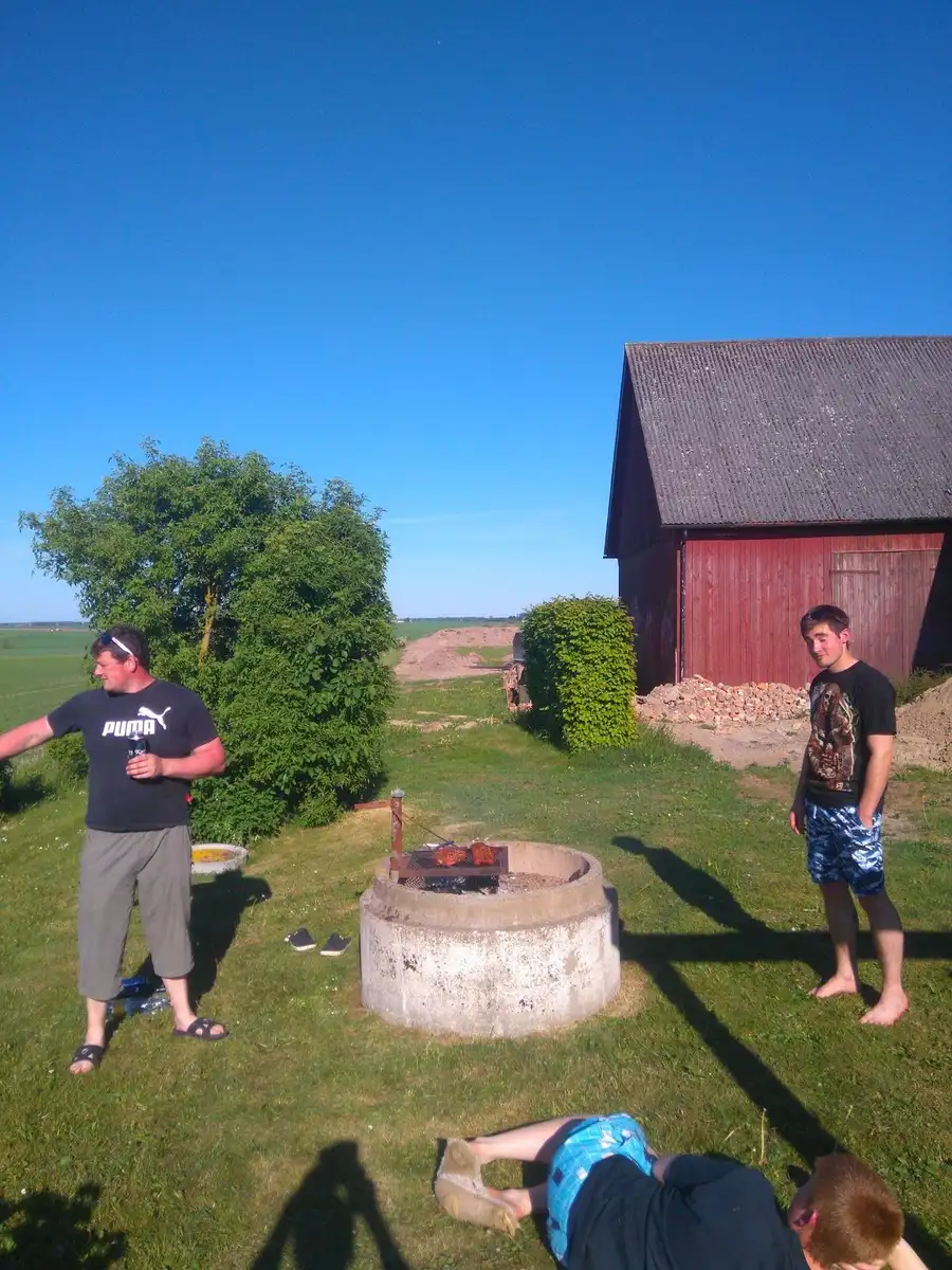 En sommardag på Hanksville Farm: människor njuter av fritid på en grön gräsmatta, omgivna av en äng, perfekt för avkoppling och semester.