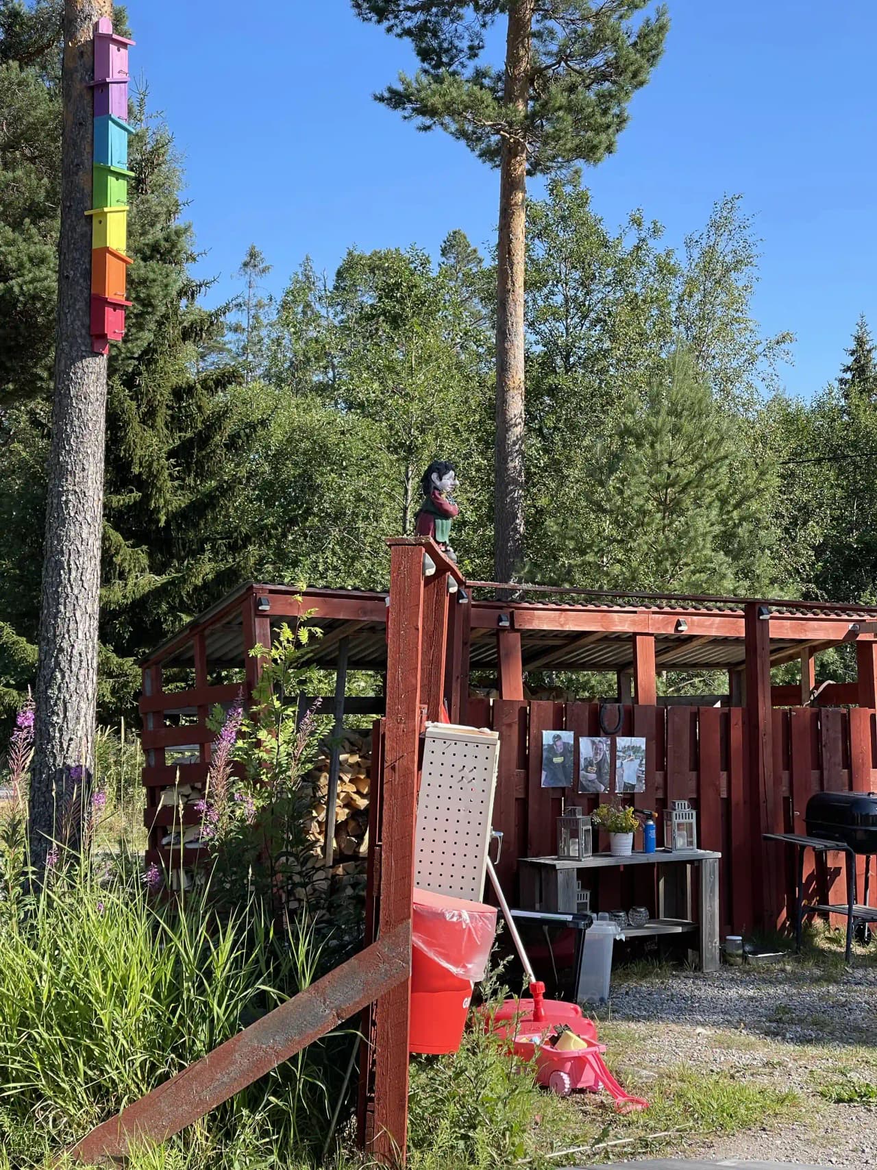 En grönskande camping vid Skärså, omgiven av träd och stugor, erbjuder skugga och naturskön miljö för rekreation.