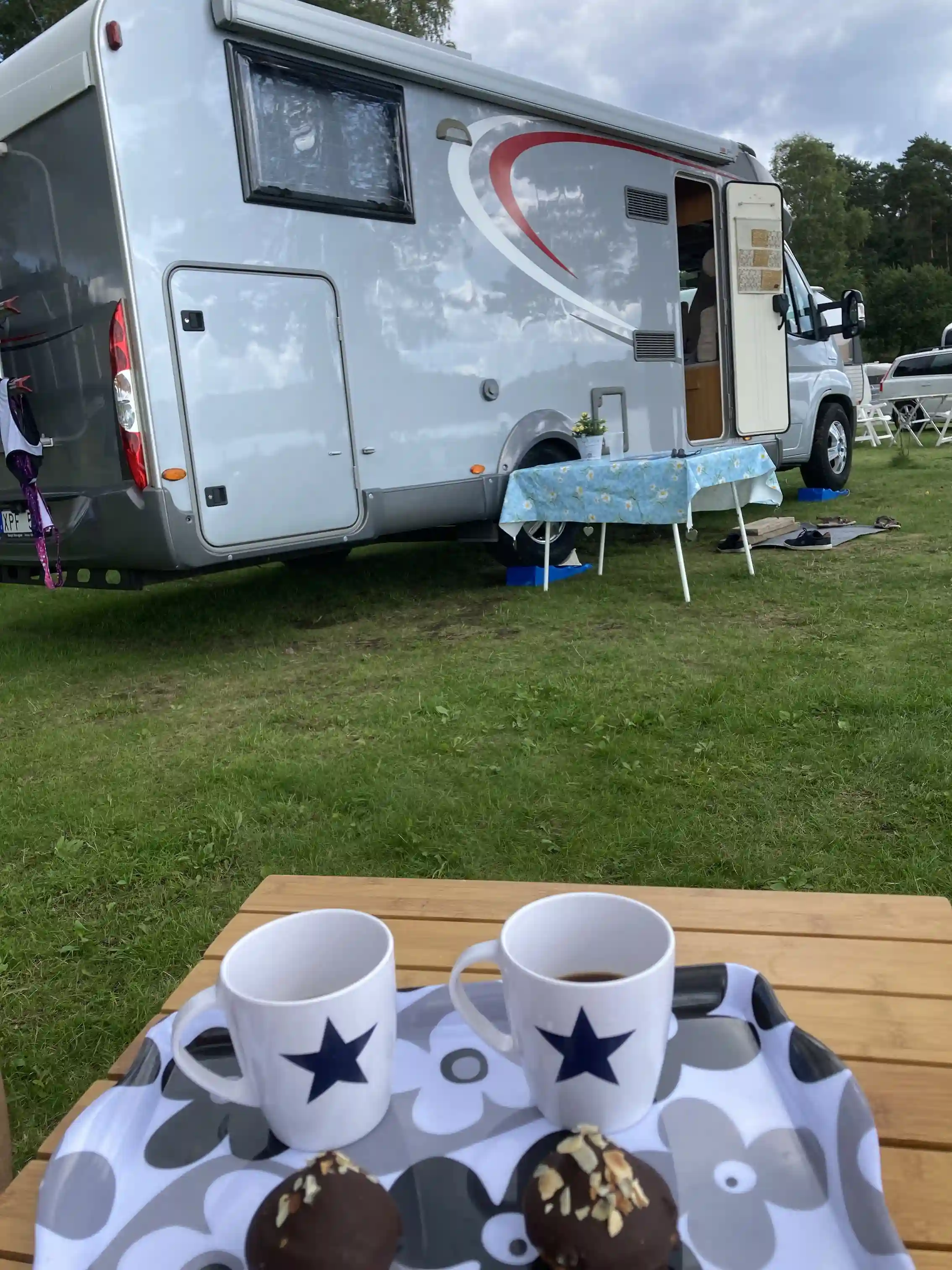 En bild från Hanatorps camping visar flera husbilar och husvagnar parkerade på platsen, omgivna av grönska. Perfekt för camping och friluftsliv.