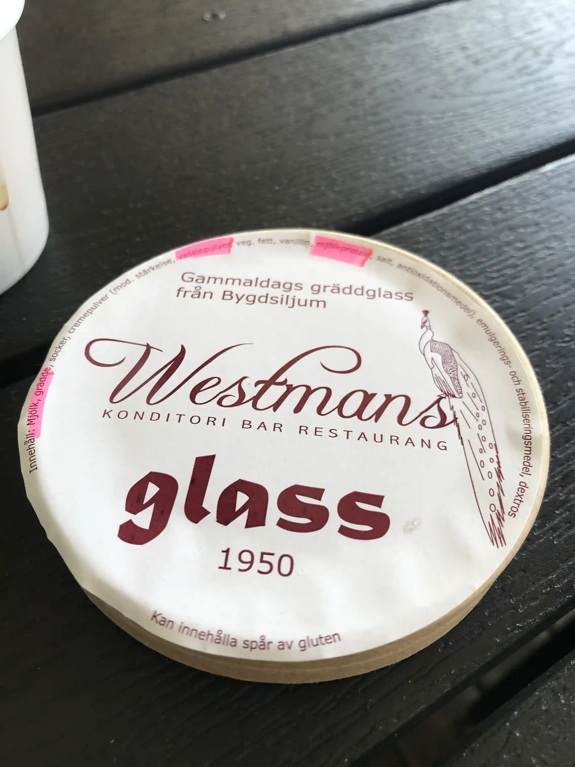 En samling tennföremål och porslin är prydligt arrangerade på ett fat, med etiketter som beskriver objekten. Bakgrunden skapar en hemtrevlig atmosfär som speglar Bygdsiljums Campings rustika charm.