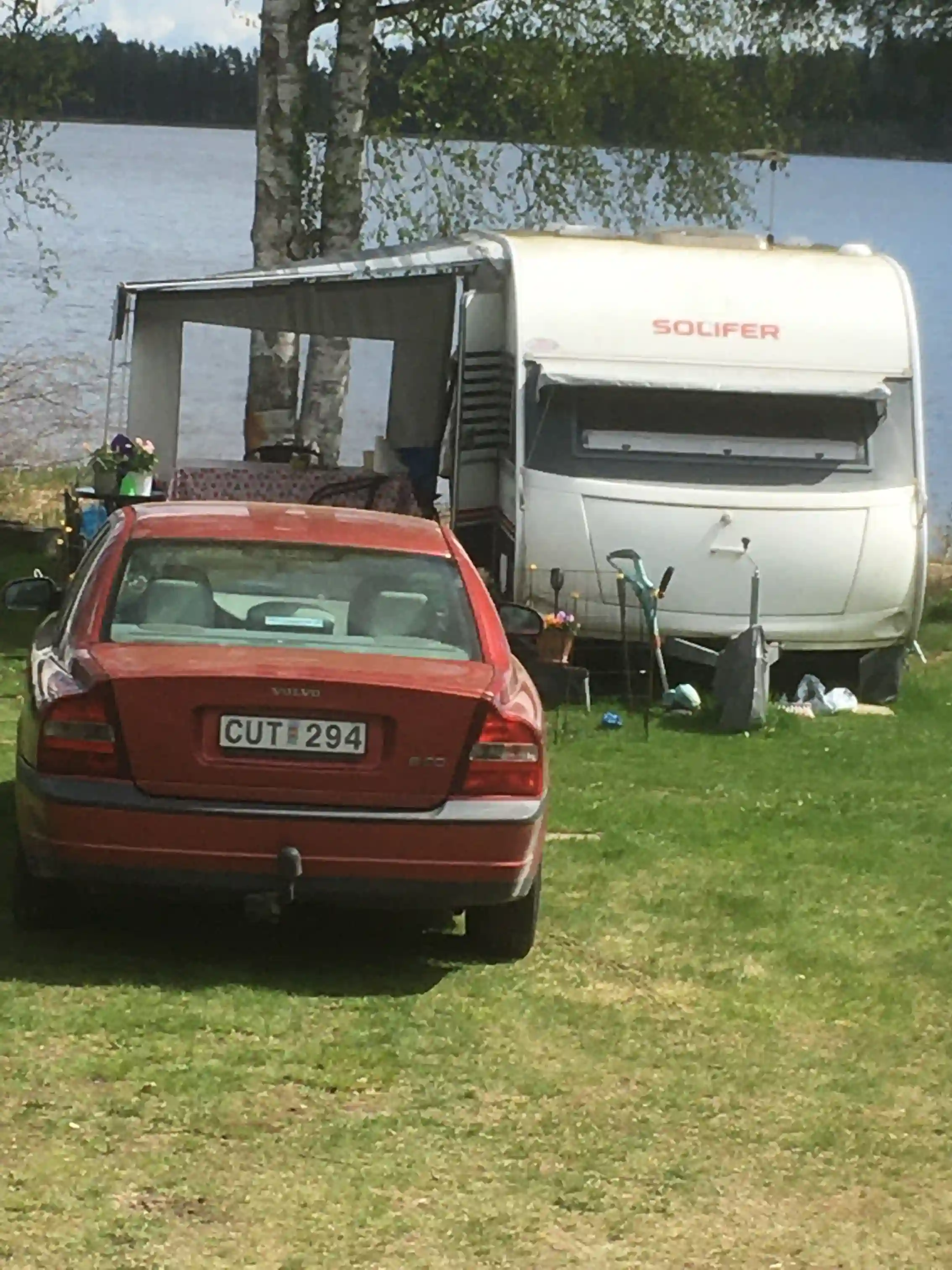 En bil parkerad vid Horndals bad & camping, med flera fordon synliga i bakgrunden.