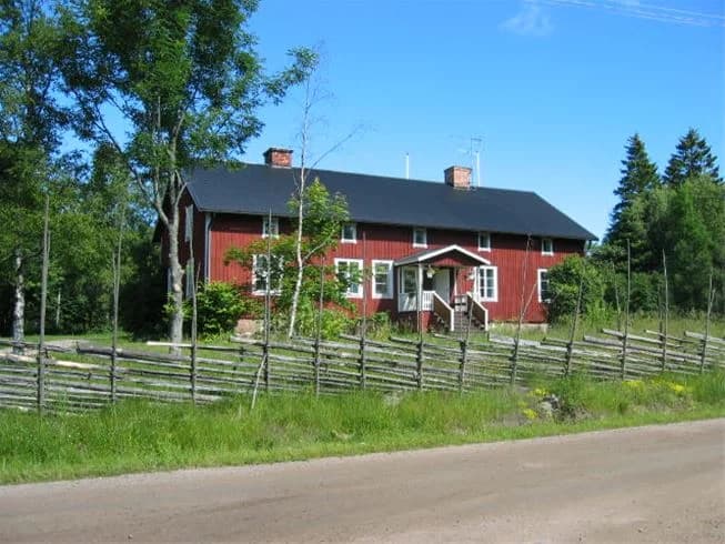 En lantlig campingplats med röda stugor och gröna omgivningar vid Kapellskär. Stugorna är byggda i traditionell stil med vita knutar, och erbjuder en avkopplande vistelse i en naturskön miljö.
