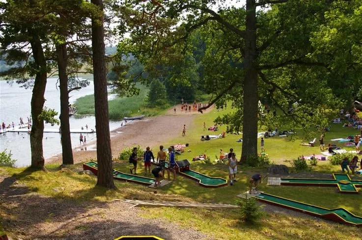 En lummig campingplats med träd och grönska, idealisk för fritidsaktiviteter och avkoppling. Parken har öppna gräsytor perfekta för picknick och semesterfirande.