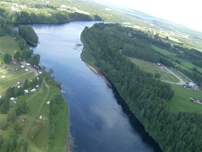 Flygbild av Storängens camping som visar en vattenväg omgivet av naturlig skönhet och flodformationer.