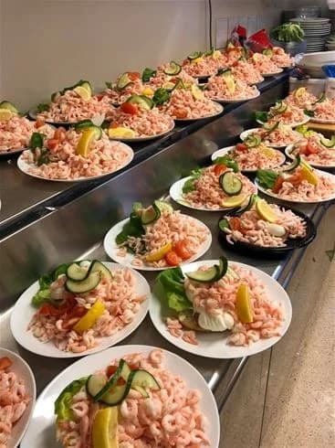 En färgglad sallad serverad på en tallrik med olika grönsaker och frukt som dekoration.